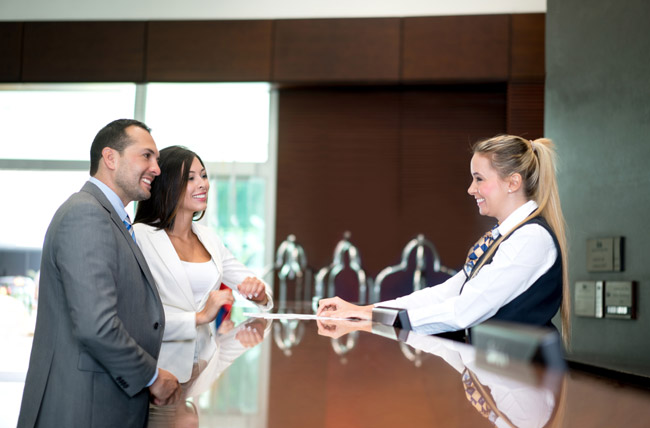 Stock photo of people checking in at hotel